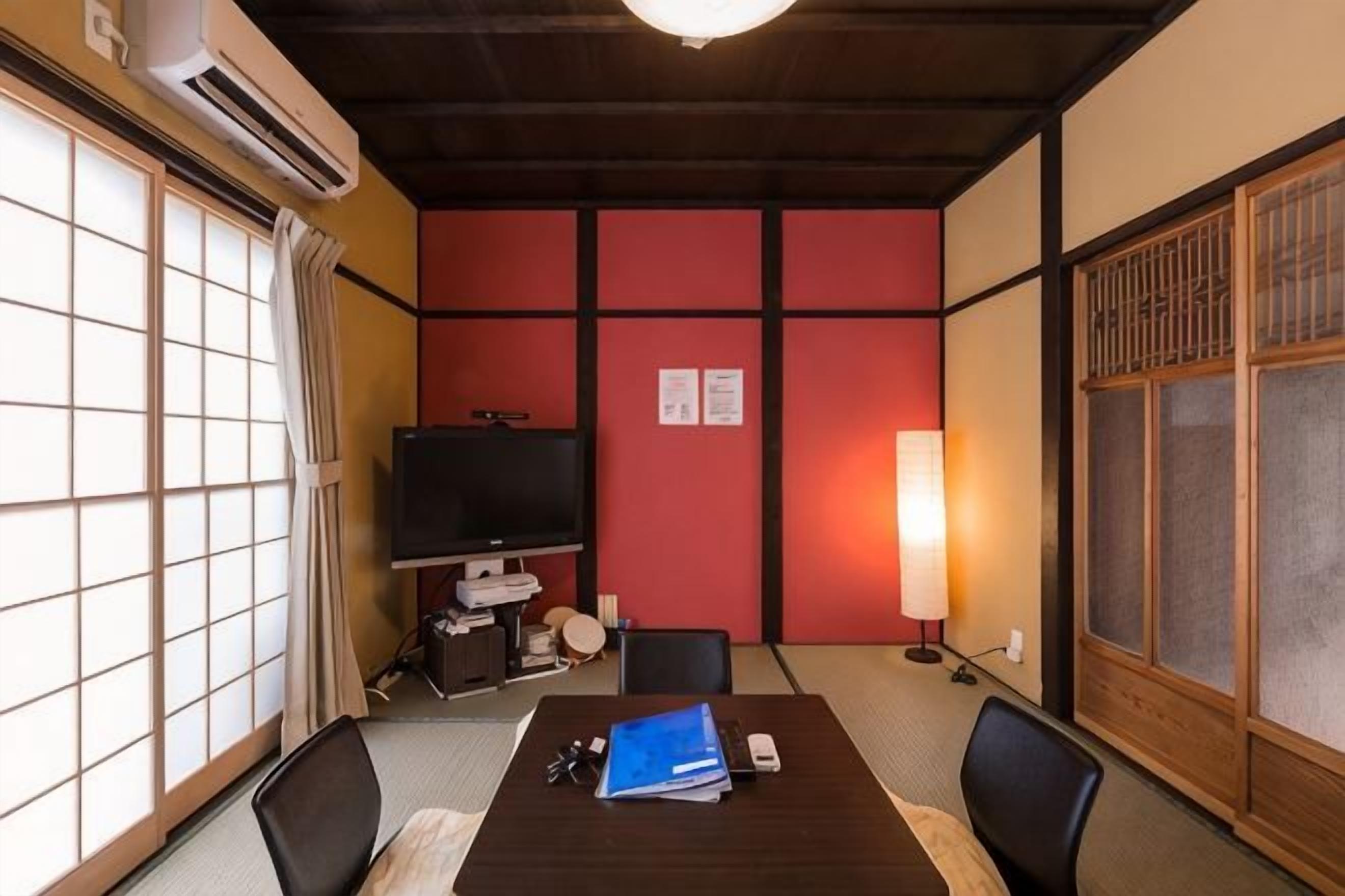 Perinteinen japanilainen huone, jossa on tatamimatto, matala pöytä, televisio ja liukuovi.