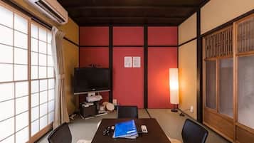 Perinteinen japanilainen huone, jossa on tatamimatto, matala pöytä, televisio ja liukuovi.