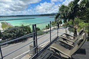 A balcony with a view of a turquoise sea and distant land. - STARS (Kunigami District)