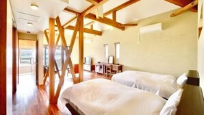 A bedroom with two beds, wooden beams, a desk, and a chair. - STARS (Kunigami District)