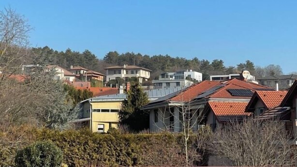 A residential area with houses, some with solar panels, surrounded by trees and vegetation. - Meszko Park House Budapest (Budapest)