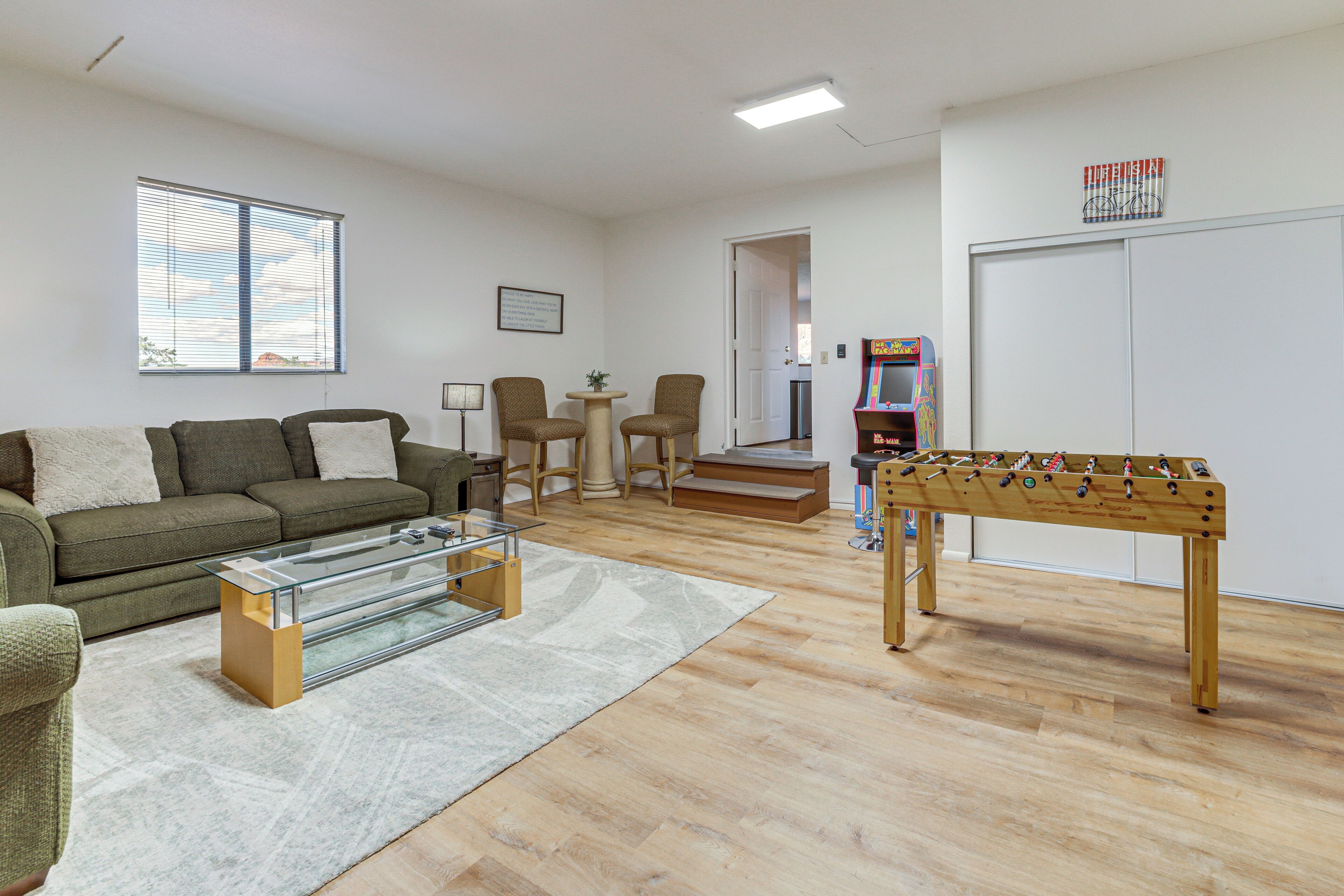 Ein Wohnzimmer mit einer Couch, einem Couchtisch und einem Kicker.