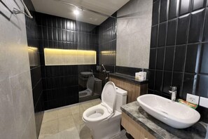 Un baño moderno con inodoro, lavamanos y ducha.