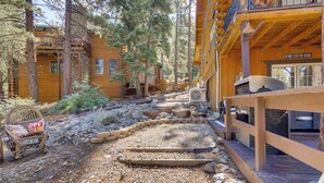 A wooden cabin with a deck, surrounded by trees. - Golf & Swim! Pine Mtn Club Retreat w/ Game Area (Pine Mountain Club)