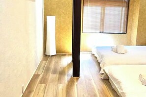 A hotel room with a wooden floor, a bed with white linens, a bedside table, and a window with blinds. - 「JIAMIN」2-9 people 2 bedrooms 2 bathrooms 1 bathroom 1 living room 1 kitchen (Osaka)