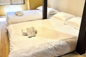 Two adjacent hotel rooms with beds, pillows, and towels. - 「JIAMIN」2-9 people 2 bedrooms 2 bathrooms 1 bathroom 1 living room 1 kitchen (Osaka)