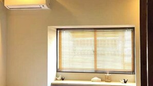 A bathroom with a window, a shelf with decorative items, and a towel rack. - JIA MING (Osaka)