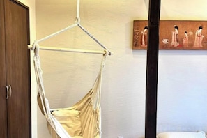 A room with a hammock chair, a wooden door, and a painting on the wall. - 「JIAMIN」2-9 people 2 bedrooms 2 bathrooms 1 bathroom 1 living room 1 kitchen (Osaka)