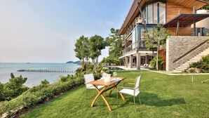 A modern house with a large balcony overlooking a body of water. - The View (Koh Samui)