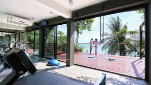 A gym with treadmills, exercise balls, and a yoga mat area. - The View (Koh Samui)
