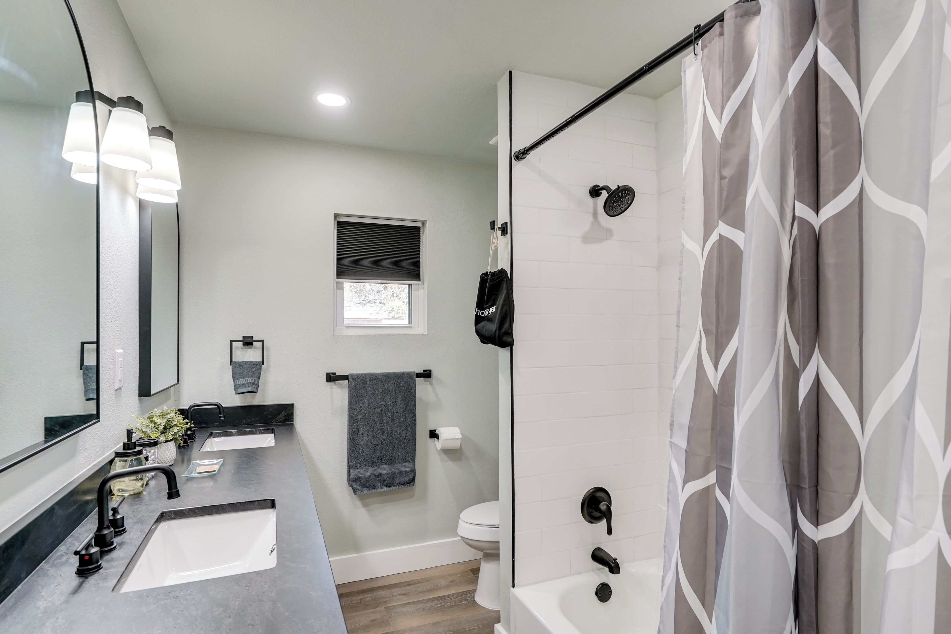 Une salle de bain moderne avec un double vasque, une douche et un grand miroir.