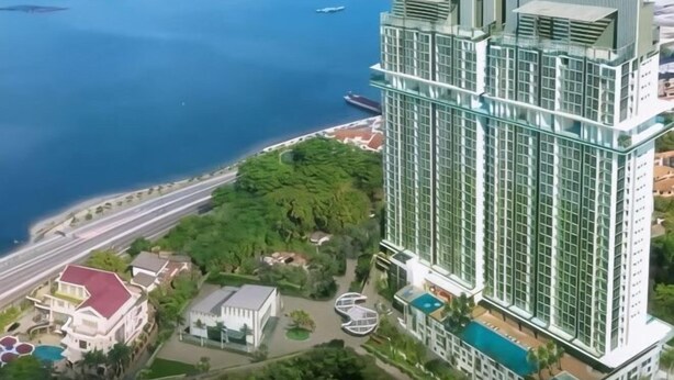 A high-rise hotel with a modern glass facade, located near a waterfront with visible boats. - Delight Homestay Paragon Residences (Johor Bahru)
