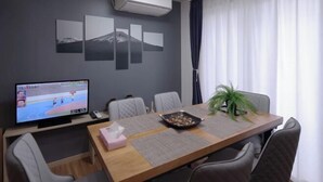 A conference room with a large table, chairs, a television, and wall art.