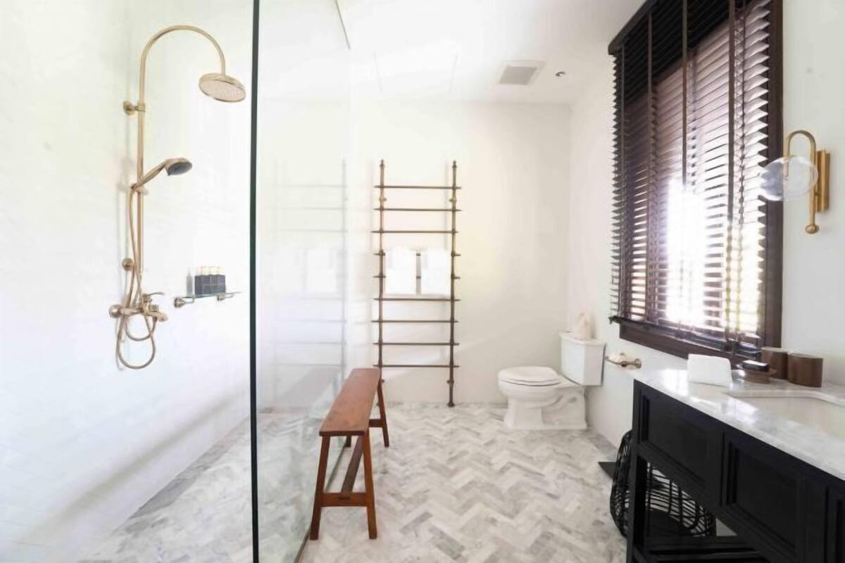 Een badkamer met een douche, toilet en wastafel.