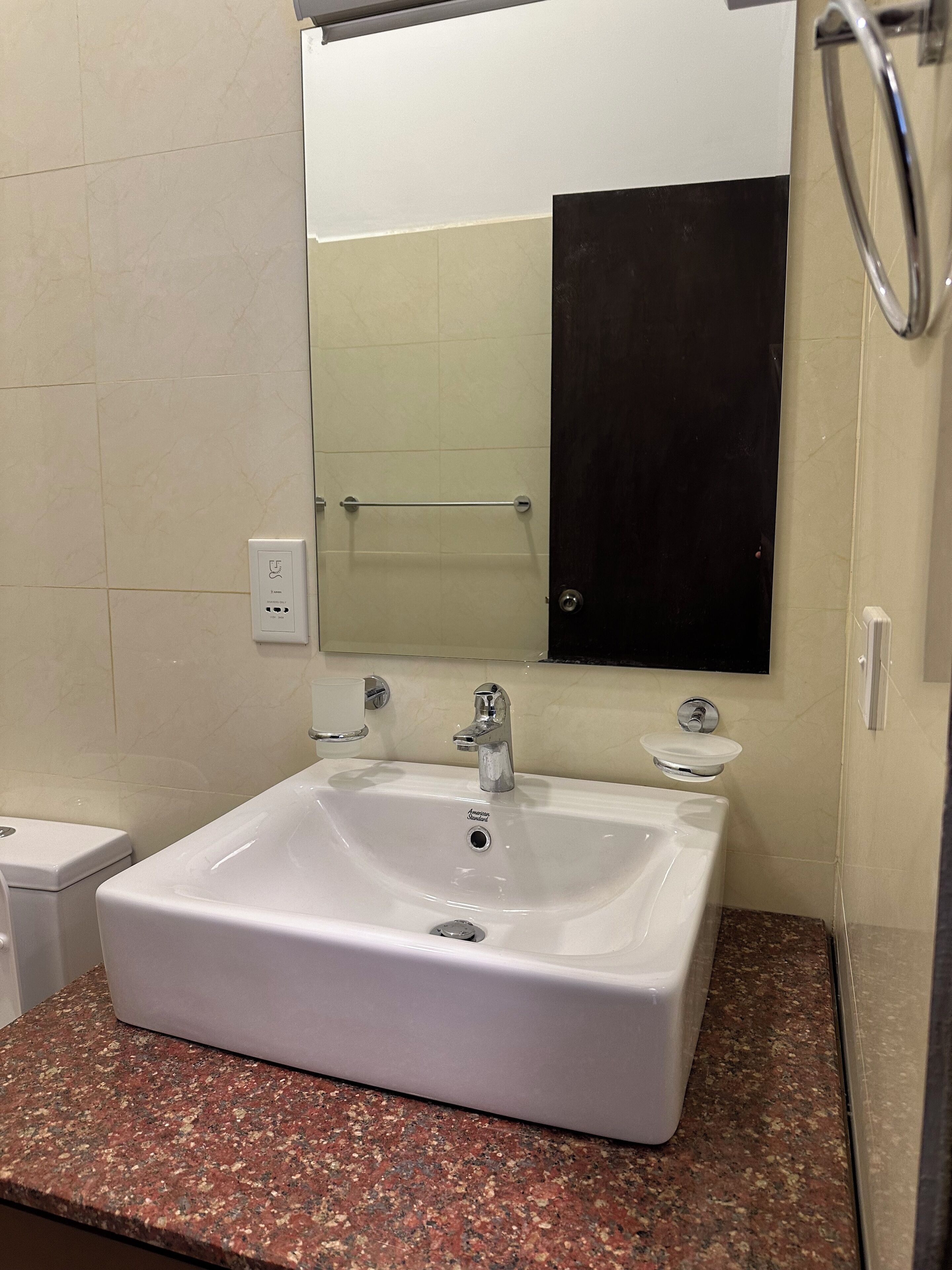 Une salle de bain avec un lavabo blanc, un miroir et un porte-serviettes.