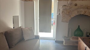 Ein Wohnzimmer mit Steinwand, einer Couch, einer Holzkiste und einem Kamin.