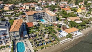 An aerial view of a coastal hotel with multiple buildings, a swimming pool, and a beach area. - Aliki's Summerhouse 2 (Argassi)