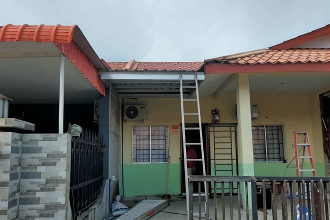 Um edifício residencial com telhado em telhas, varanda coberta e escada.