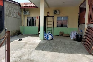 A covered outdoor area with a concrete floor, a door, and two air conditioning units on the wall. - Comfy Transit Tawau-Semporna (Tawau)