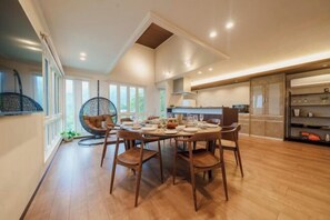 A dining area with a round table, chairs, and a hanging chair. - Villa Atami (Atami)