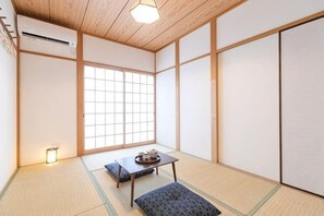 Una tradizionale stanza giapponese con pavimento in tatami, un tavolino con un vassoio e porte scorrevoli.