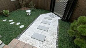 A garden pathway with stepping stones, a small white lantern, and a wooden fence. - KIRAKU･RAKUTEI (Kyoto)