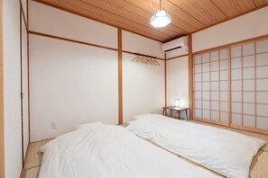 A traditional Japanese-style room with tatami flooring, a low wooden ceiling, and a sliding shoji screen. - KIRAKU･RAKUTEI (Kyoto)