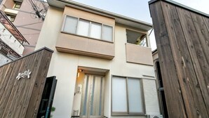 A modern two-story building with a wooden gate, a front door, and a small front yard. - KIRAKU･RAKUTEI (Kyoto)