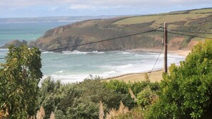 Un paisaje costero con acantilados, olas del océano y vegetación.
