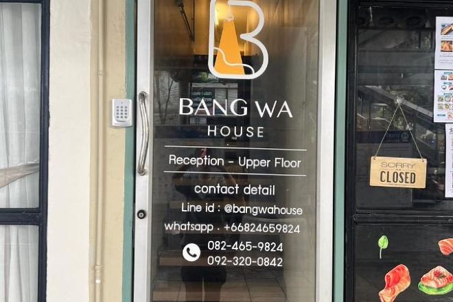 A hotel entrance with a reception sign on the upper floor and a closed sign on the right.