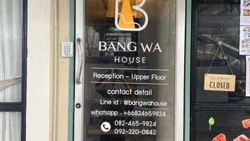 A hotel entrance with a reception sign on the upper floor and a closed sign on the right.