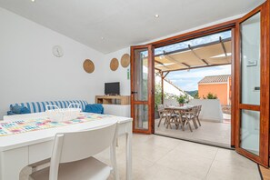 A dining area with a table, chairs, and a TV.