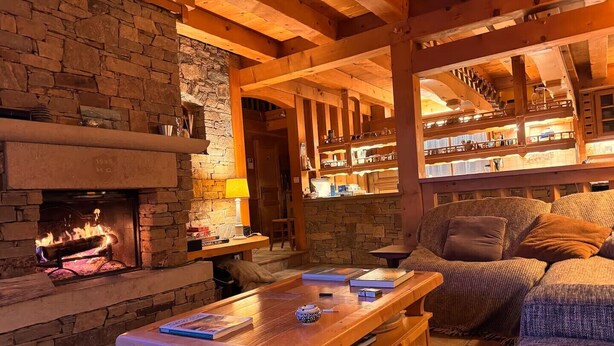 A cozy living room with a stone fireplace, wooden beams, and a comfortable seating area. - 10 min from Lake Annecy, large, quiet chalet with view (Faverges-Seythenex)