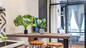 Een moderne keuken met een houten aanrecht, barstoelen en potplanten.