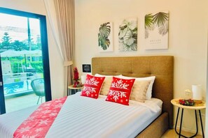 A hotel room with a bed, a small table with a lamp, and a view of the outdoors. - Relax Pool Villa Khaoyai (Pak Chong)