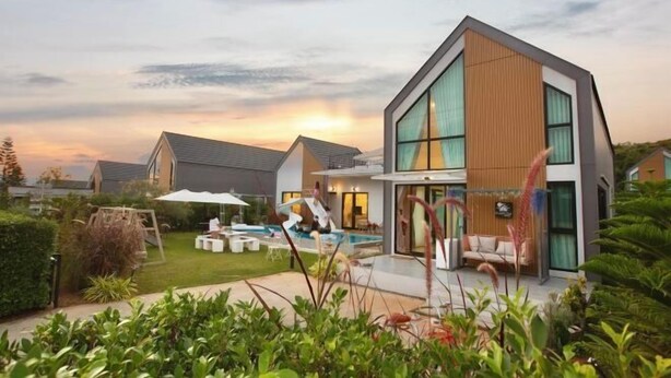 A modern two-story house with a swimming pool, outdoor seating, and a well-maintained garden. - Relax Pool Villa Khaoyai (Pak Chong)