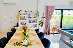 A dining area with a long table, chairs, a bookshelf, and a pool table. - Relax Pool Villa Khaoyai (Pak Chong)
