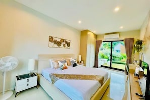 A modern hotel room with a large bed, bedside table, and a window with curtains. - Relax Pool Villa Khaoyai (Pak Chong)