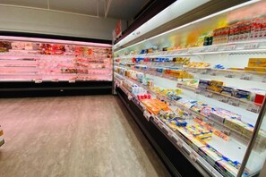 A grocery store with refrigerated sections and shelves stocked with various products. - Japanese house for touring (Nachikatsuura)