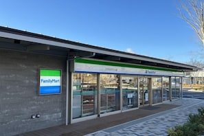 A FamilyMart store with a clear entrance and a covered waiting area. - Private Japanese-style house for families and groups (Okuma)
