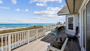 A wooden deck with a railing overlooking a beach, a covered seating area, and a view of the ocean. - SS2-Oceanfront w/7 masters, private pool & hot tub, elevator & pool table (Southern Shores)
