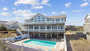 A two-story building with a balcony and a swimming pool. - SS2-Oceanfront w/7 masters, private pool & hot tub, elevator & pool table (Southern Shores)