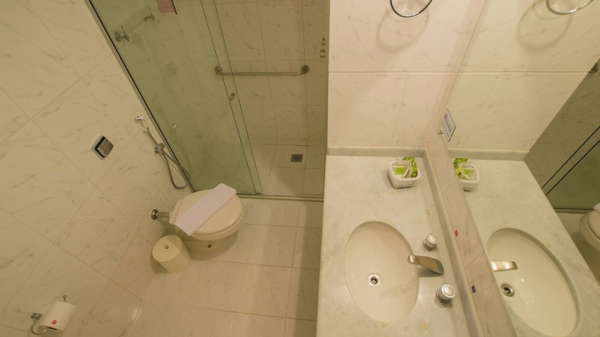 A bathroom with a toilet, bidet, and two sinks.
