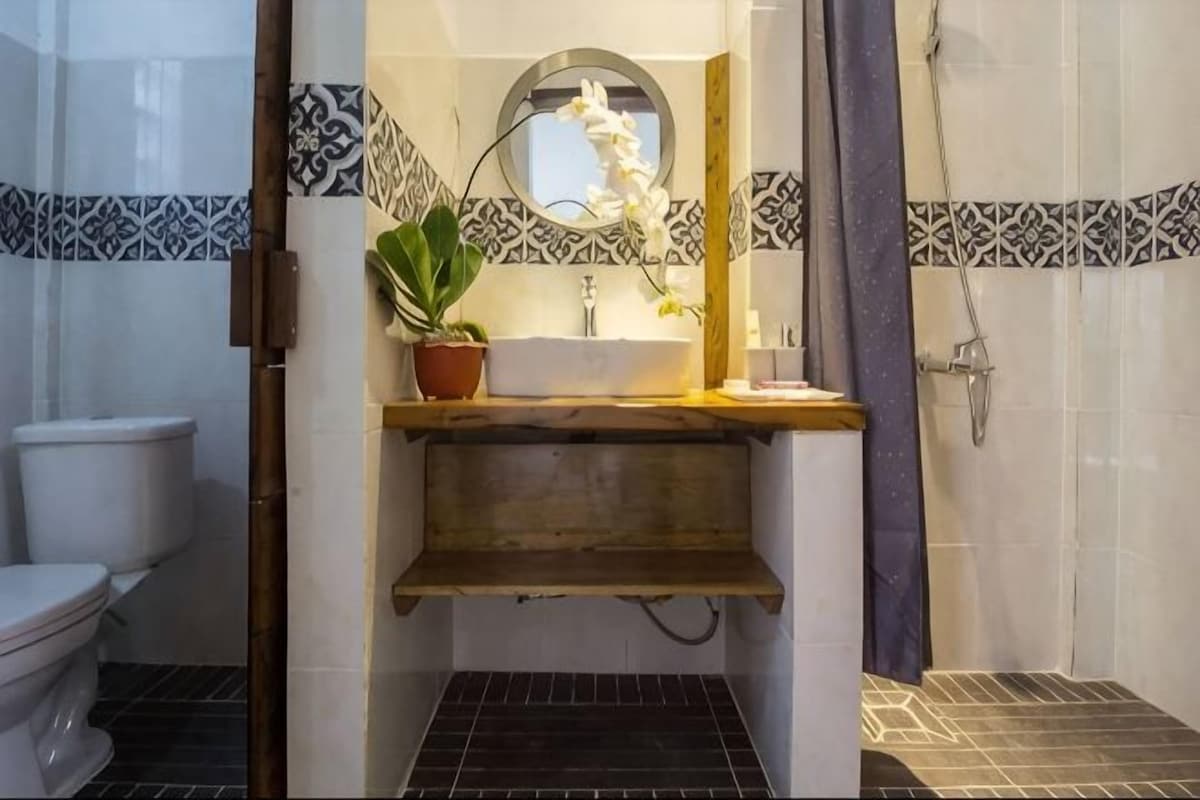 A bathroom with a toilet, sink, and shower.