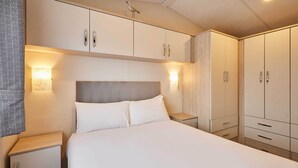 Une chambre à coucher avec un lit, des tables de chevet et des armoires encastrées.