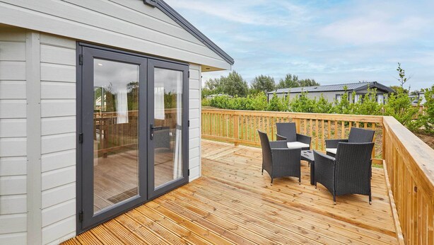 Une terrasse dotée de mobilier d’extérieur et d’une porte-fenêtre coulissante donnant sur une pièce.