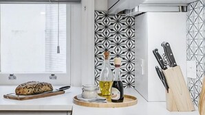 A kitchen with a loaf of bread, a bottle of oil, and a knife block on the counter. - Kula London - Covent Garden St Martin's Lane (London)