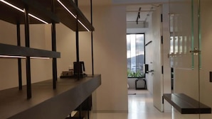 A modern interior with a long, narrow hallway leading to a room with a large window. - Pause Apartment (Dalat)