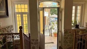 A staircase leading to an outdoor area with a view of a patio and a building in the background. - Archontiko Hotel (Kalymnos)