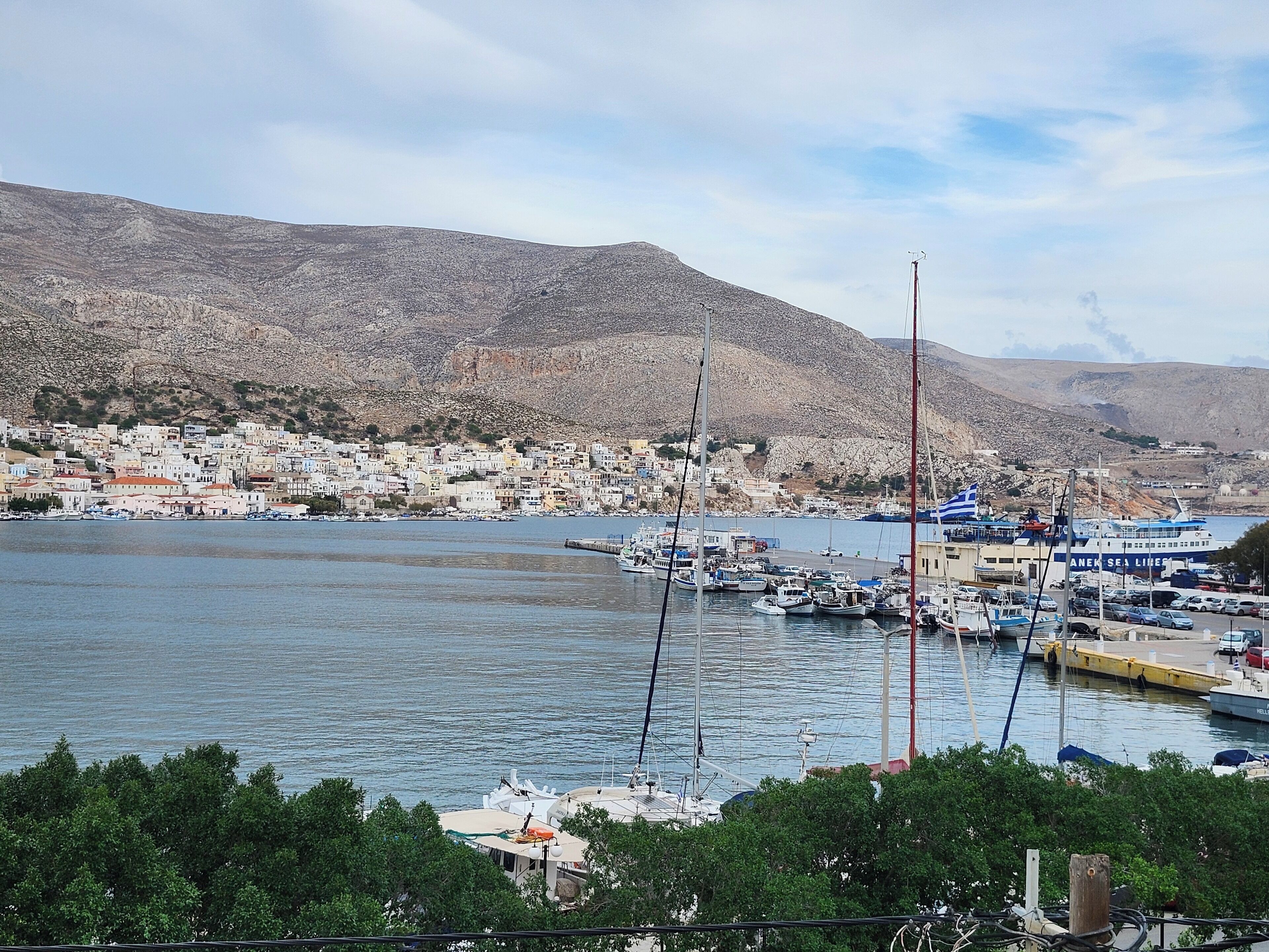 Un puerto con barcos y un pueblo al fondo.